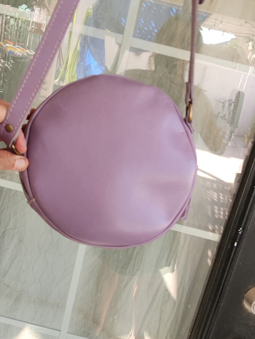 The purple round bag in the image is a Circle Crossbody in the color Lavender - Picture 5 of 8